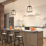 A modern kitchen with white cabinets, subway tile backsplash, a large wooden island with three black chairs, pendant lights, and bowls of oranges as decor. Exposed brick and stainless steel appliances are visible.