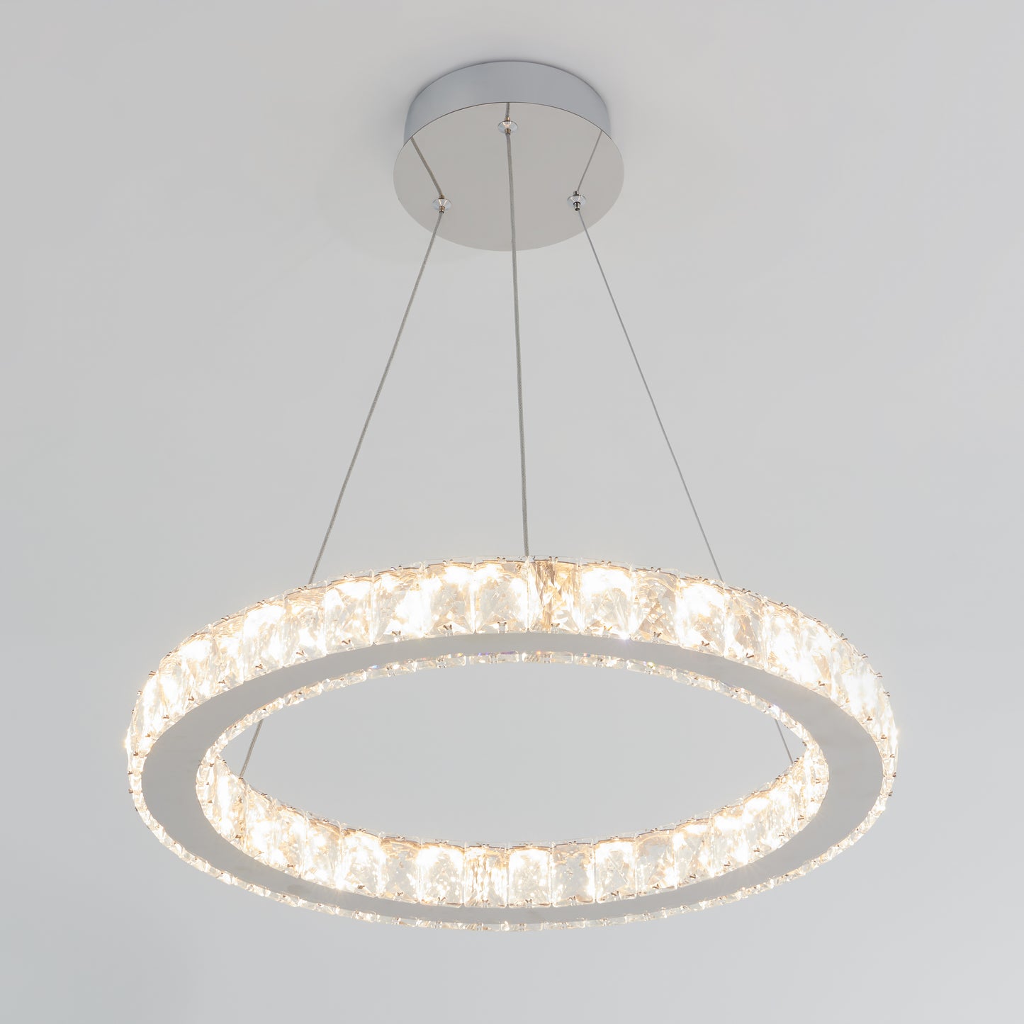 The Artika Celebrity LED pendant light features a modern circular design with crystal-like elements, suspended by three thin wires, and emits a bright, even light.