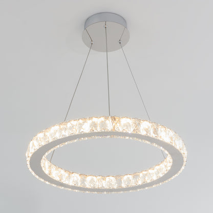 The Artika Celebrity LED pendant light features a modern circular design with crystal-like elements, suspended by three thin wires, and emits a bright, even light.