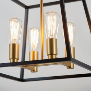 Close-up of the Artika Carter Square 4-light chandelier, featuring black and gold finishes with exposed Edison-style bulbs.