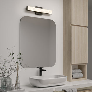 Modern bathroom with a rectangular mirror, vessel sink, wooden shelves, and Artika Adeline 18-in LED vanity light bar.