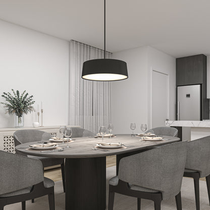 Modern dining room with a dark oval table for six, gray upholstered chairs, and minimalist decor including greenery and candles. Overhead, the Artika Groove Drum LED contemporary pendant light 3 CCT adds a stylish touch, with the kitchen visible in the background.