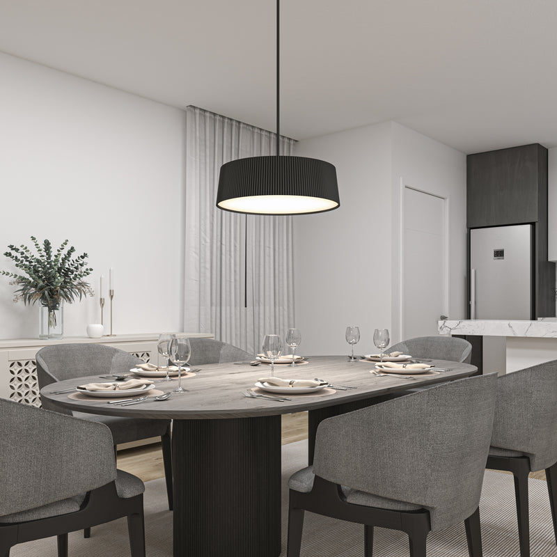 Modern dining room with a dark oval table for six, gray upholstered chairs, and minimalist decor including greenery and candles. Overhead, the Artika Groove Drum LED contemporary pendant light 3 CCT adds a stylish touch, with the kitchen visible in the background.