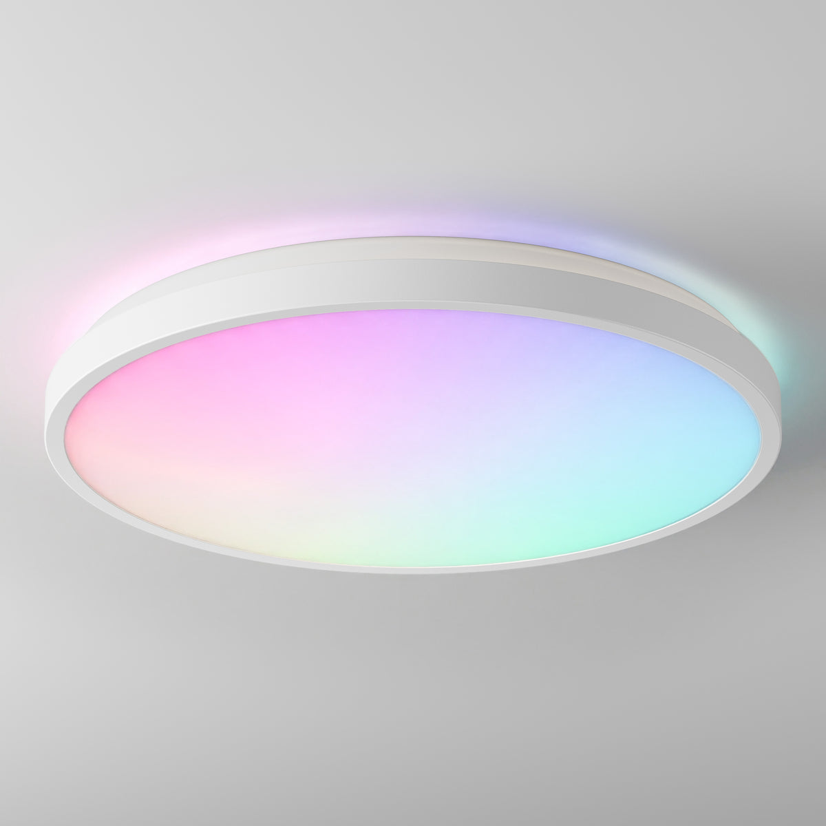 The Artika Isara 15″ RGBIC LED Ceiling Light shines gradient pink, blue, green, and purple hues on a white ceiling.