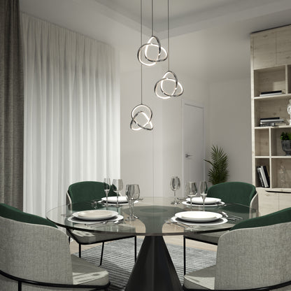 A modern dining room with a round glass table set for four, green upholstered chairs, sheer curtains, a light wood shelving unit with decor, and the Artika Zephyr 3-light LED pendant as stylish modern lighting.