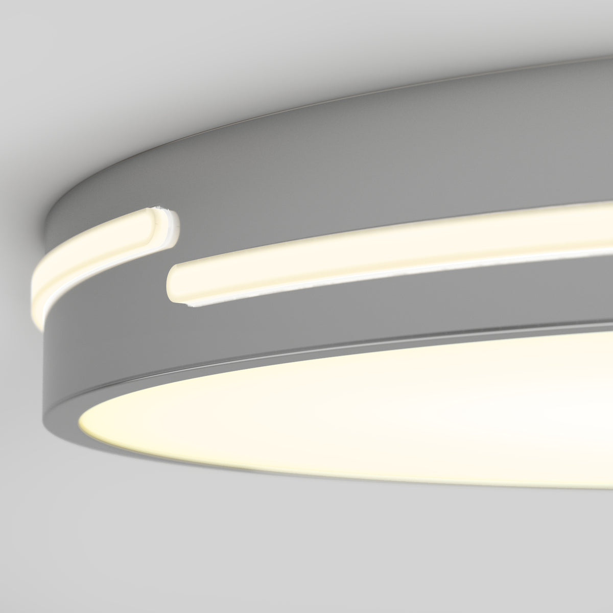 Close-up view of a modern, circular ceiling light fixture with a smooth, matte gray finish and illuminated white LED strips embedded around the edge.