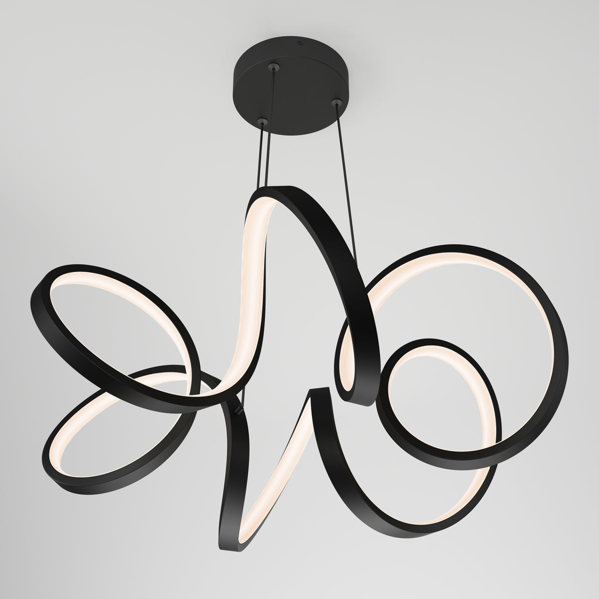 Modern black ceiling light fixture with three intertwined, looping LED rings suspended by cables from a round base, set against a plain white background.
