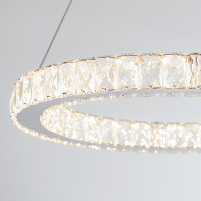 A close-up of the Artika Celebrity LED pendant light, a modern circular chandelier suspended by thin wires, emits bright sparkling light against a plain white background.