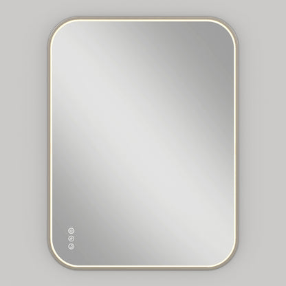 The Artika Royce Dimmable LED Mirror, 3 CCT, is mounted on a light gray wall and glows softly at the edges. Three touch buttons on the lower left offer adjustable color temperature and defogger settings.