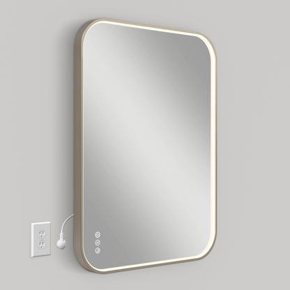 The Artika Royce Dimmable LED Mirror, mountable horizontally or vertically, features rounded corners, a built-in LED border with 3 adjustable color temperatures, and touch controls. An electrical cord plugs into a nearby outlet on the light gray wall.