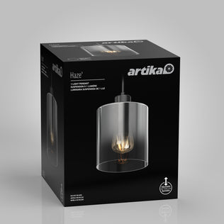 A black Artika box displays the Haze pendant light glass with an exposed bulb and clear glass design. The packaging features product and installation info in English, French, and Spanish.