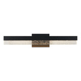 A modern wall-mounted light fixture with a rectangular black frame, a central bronze accent, and a textured glass diffuser running horizontally along the bottom.