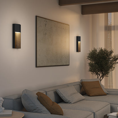 Modern living room featuring a gray sectional sofa with brown cushions, a large abstract painting, and two Artika Howel modern LED indoor-outdoor wall lights (5 CCT) emitting warm light, plus a potted plant and sheer curtains on a big window.