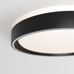 Close-up of the Artika Callisto 15 in. LED flush mount light 5 CCT, featuring a modern design with a black outer ring and white frosted diffuser, mounted on a white ceiling.