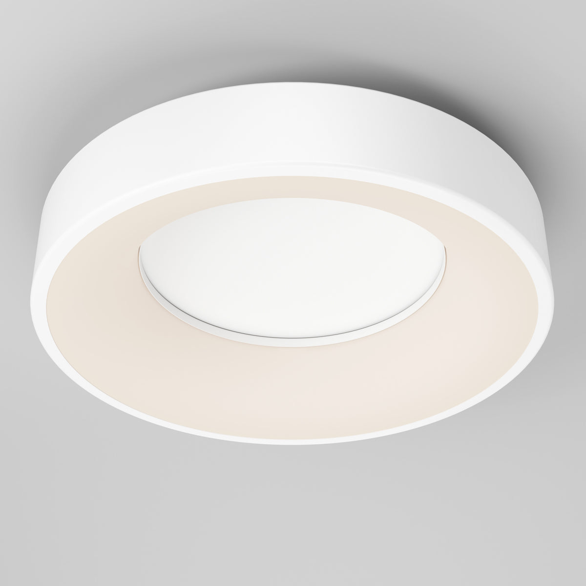 A modern, circular white ceiling light fixture with a minimalistic design, mounted on a light gray ceiling. The fixture emits a soft, even glow from its inner ring.