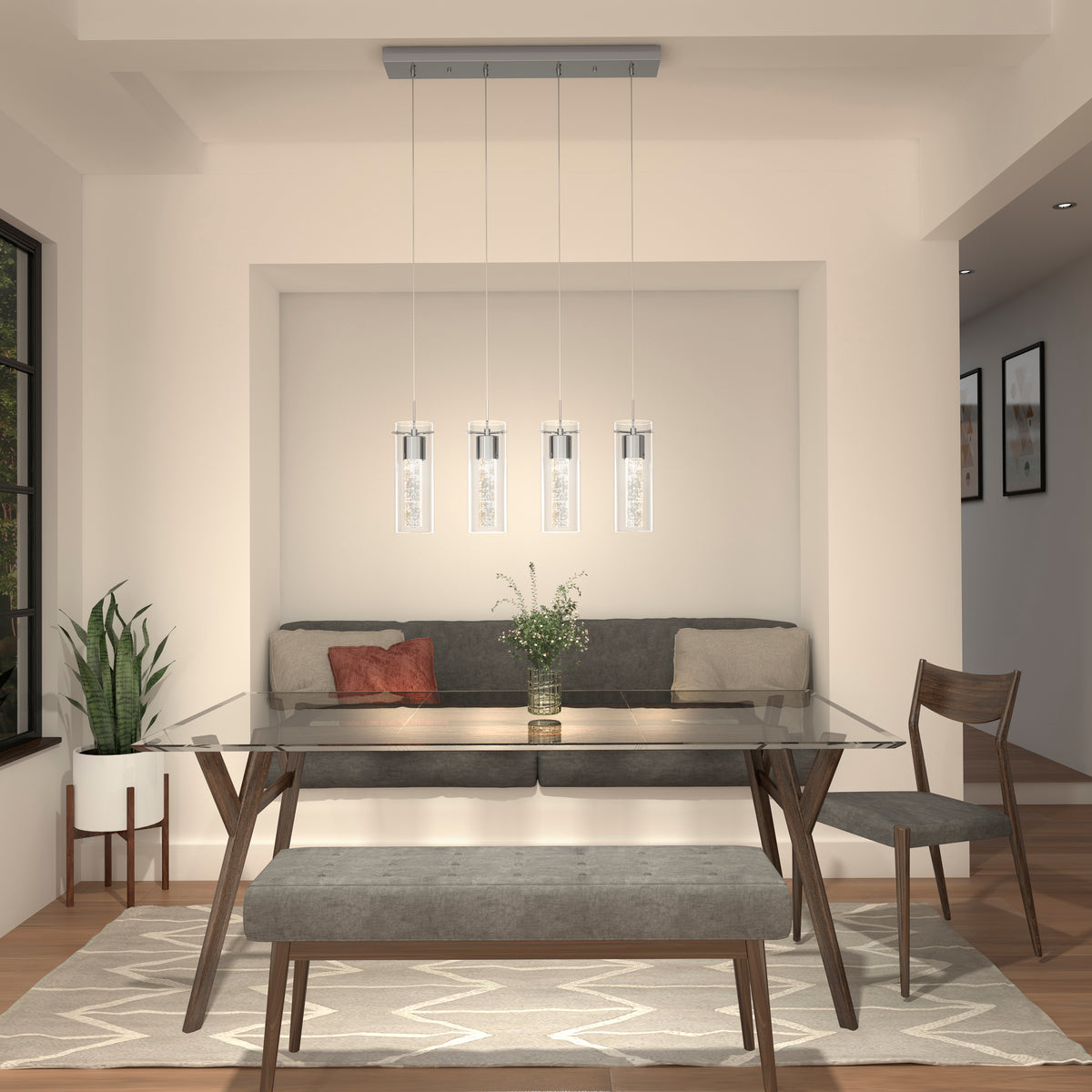 Modern dining room with a glass table, gray bench, wooden chairs, a plant, wall art, and a pendant light fixture with four lights hanging above the table. Neutral tones and minimalist decor create a cozy, inviting space.