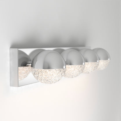 The Artika Carat LED bathroom vanity light features four chrome and textured glass globe lights on a sleek rectangular base, providing soft illumination for your space.
