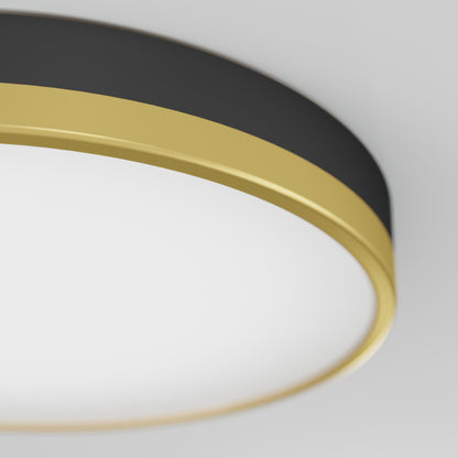 Close-up of the Artika Kent LED flush mount light featuring a round black and gold frame with a white diffuser, shown against a light gray background.