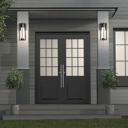 A modern double front door with glass panels, framed by two Artika Walt indoor-outdoor LED wall lights and potted plants on each side, set against gray siding with steps leading to the entrance.