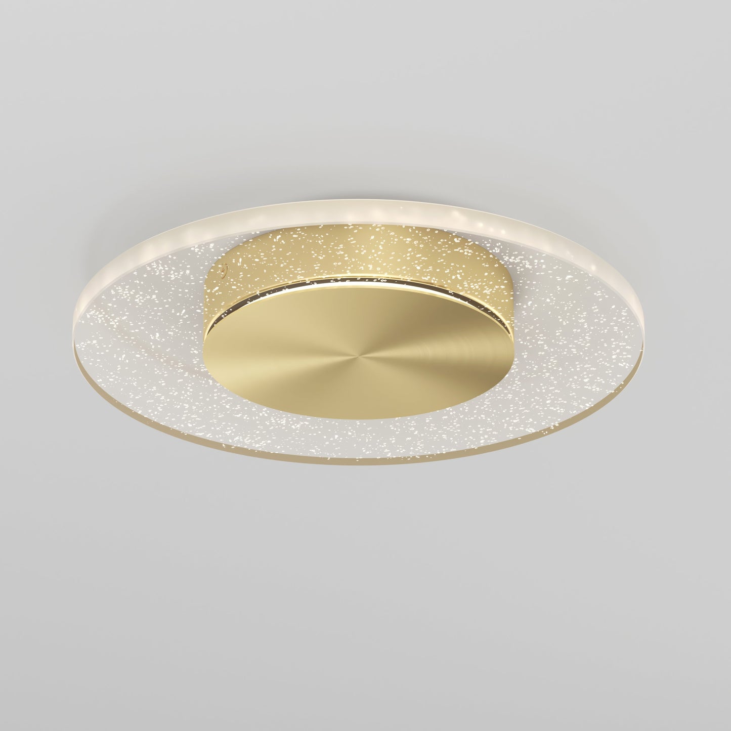The Artika-CAN-dev Essence Disk LED flush mount is a modern ceiling light with a round gold center and a haloed glass diffuser featuring sparkling lights, displayed on a light gray background.