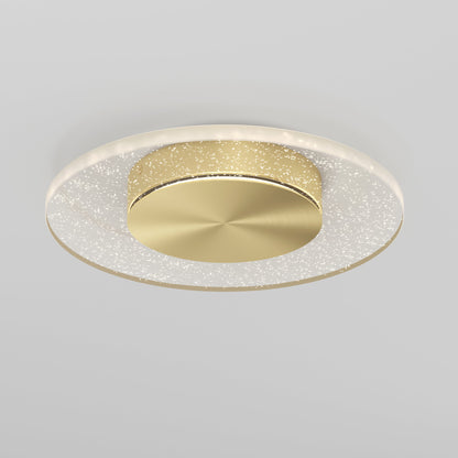 The Artika-CAN-dev Essence Disk LED flush mount is a modern ceiling light with a round gold center and a haloed glass diffuser featuring sparkling lights, displayed on a light gray background.