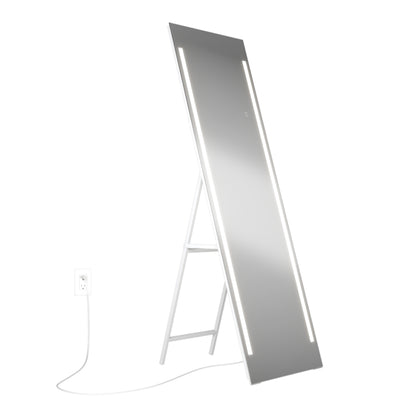 The Artika Emeraude Full Length Mirror is a tall, rectangular, free-standing mirror with dual vertical LED light strips, angled on a white stand and plugged into a white electrical outlet.