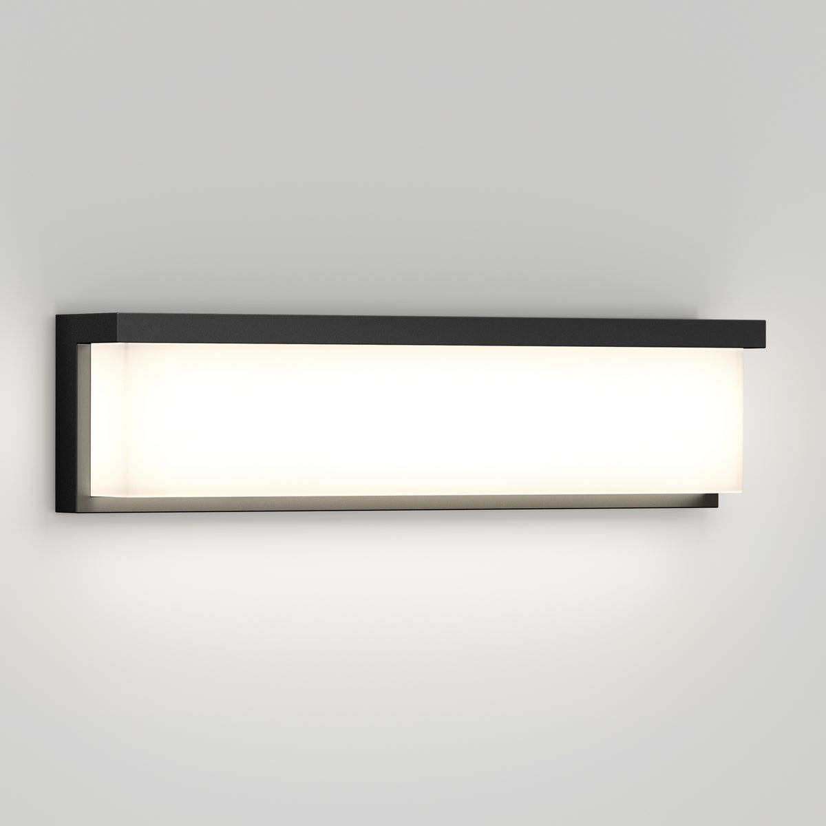 A modern rectangular wall sconce with a black frame and a frosted white diffuser, mounted on a light gray wall and emitting a soft, even glow.