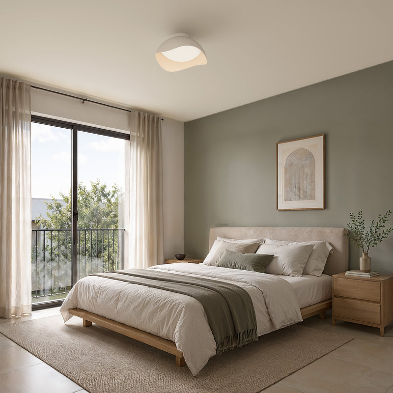 An Artika Adara 15 in. (38 cm) Modern LED Flush Mount Ceiling Light 5 CCT in a white, wave-shaped dimmable design installed in a bedroom.