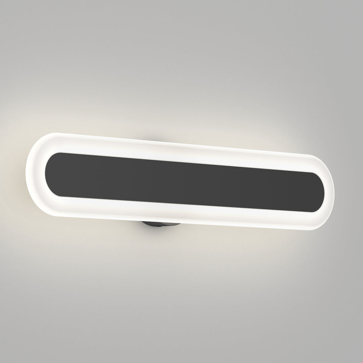 A modern, oval-shaped wall light fixture with a black center and a white illuminated border, mounted on a light gray wall.