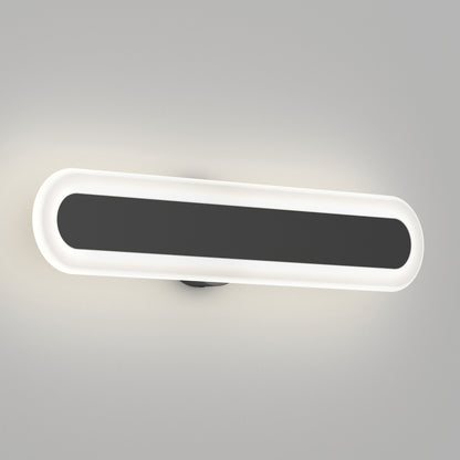 The Artika Pista modern LED bathroom vanity light 5 CCT features an elongated oval shape with a black center and glowing white border, wall-mounted on a plain light gray surface.