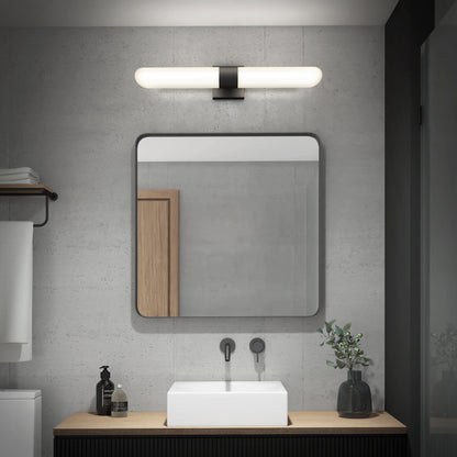 Modern bathroom featuring the Artika Wilton LED modern bathroom vanity light 5 CCT above a large square mirror, a white rectangular sink on a wooden countertop with black faucet, soap dispenser, small plant in vase, and neutral gray walls.