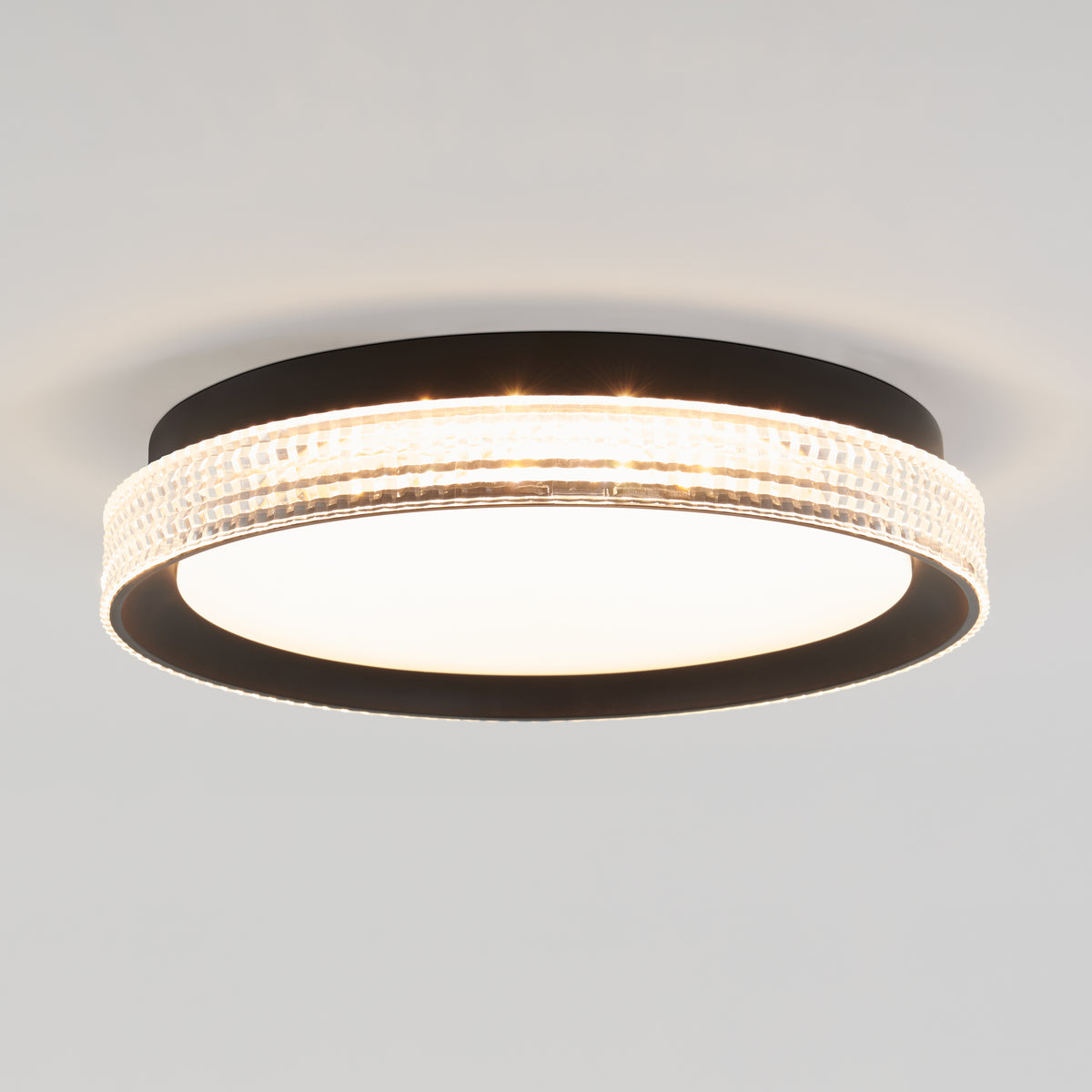 The Artika Aston 15 in. LED modern flush mount light features a round black frame, frosted white diffuser, and an illuminated textured edge band, stylishly mounted on a white ceiling.