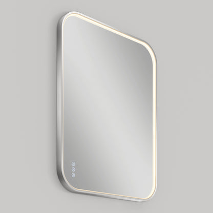 A rectangular, wall-mounted mirror with rounded edges, featuring an illuminated border and three touch-sensitive buttons in the bottom left corner, set against a plain gray background.