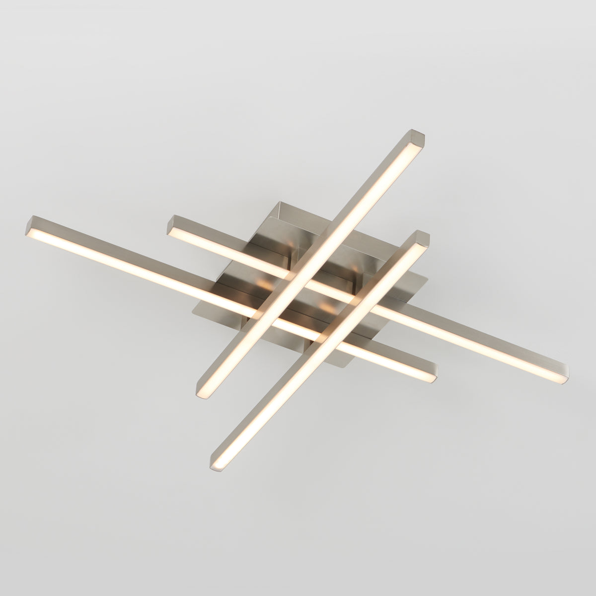 A modern ceiling light fixture with four illuminated, intersecting linear bars in a crisscross pattern, mounted on a square metallic base against a plain white background.