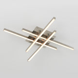A modern ceiling light fixture with four illuminated, intersecting linear bars in a crisscross pattern, mounted on a square metallic base against a plain white background.