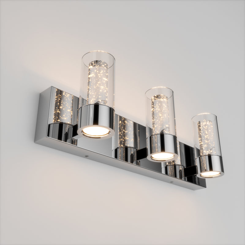 The Artika Essence 3 LED bathroom vanity light features chrome finish and three glass shades, elegantly mounted on a white wall.