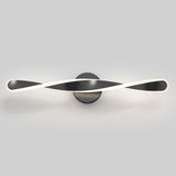 A modern wall light fixture with a twisted, ribbon-like design in black and white, mounted on a circular base against a plain gray background.