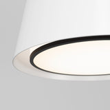 Close-up of a modern, white ceiling lampshade with a black inner rim, glowing softly against a light gray background.