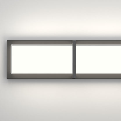 The Artika Subway LED bathroom vanity light features a modern rectangular design with a dark frame and central vertical divider, mounted on a white wall and providing a soft, even glow.