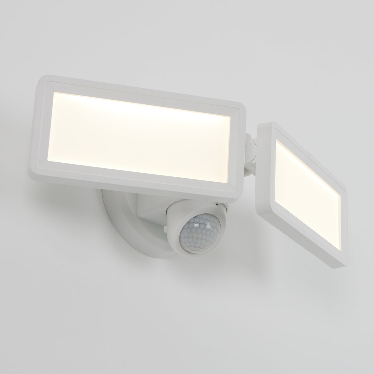 The Artika Sentinel outdoor Flat Panel Security light is a modern white LED fixture with two adjustable rectangular panels and a motion sensor, mounted on a white wall.