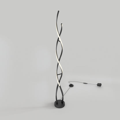 The Artika Swirl modern LED floor lamp features three intertwining rods—two black and one illuminated—on a round base with a visible power cord and adapter, displayed against a plain light gray background.