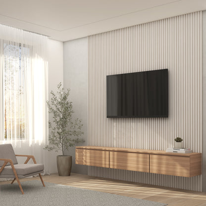 A modern living room featuring the Artika Panolok 30.67 ft wall panel kit (pack of 8), a large wall-mounted TV, wooden floating console, gray armchair, potted plant, and sheer curtains letting in natural light.