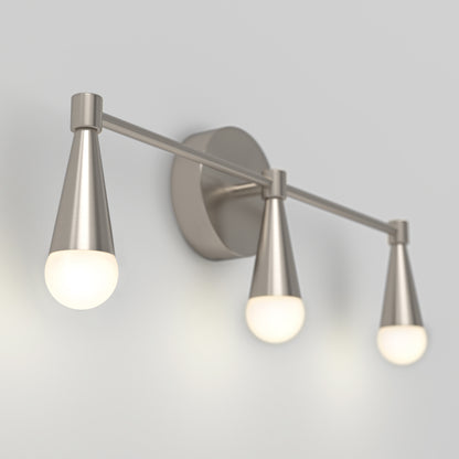 The Artika Wayden LED mid-century bathroom vanity light features three cone-shaped brushed metal lamps with frosted glass bulbs, arranged in a row on a horizontal bar, and offers 3 selectable color temperatures.