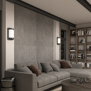 Modern living room with a gray sectional, cushions, round wood coffee table, built-in bookshelves, and Artikas Fogo modern LED indoor-outdoor wall lights on a large gray accent wall.