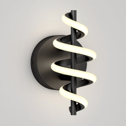 The Chorus LED Wall Light by Artika features a black circular base and a vertical rod wrapped in a glowing spiral LED, shown mounted on a plain light gray wall.