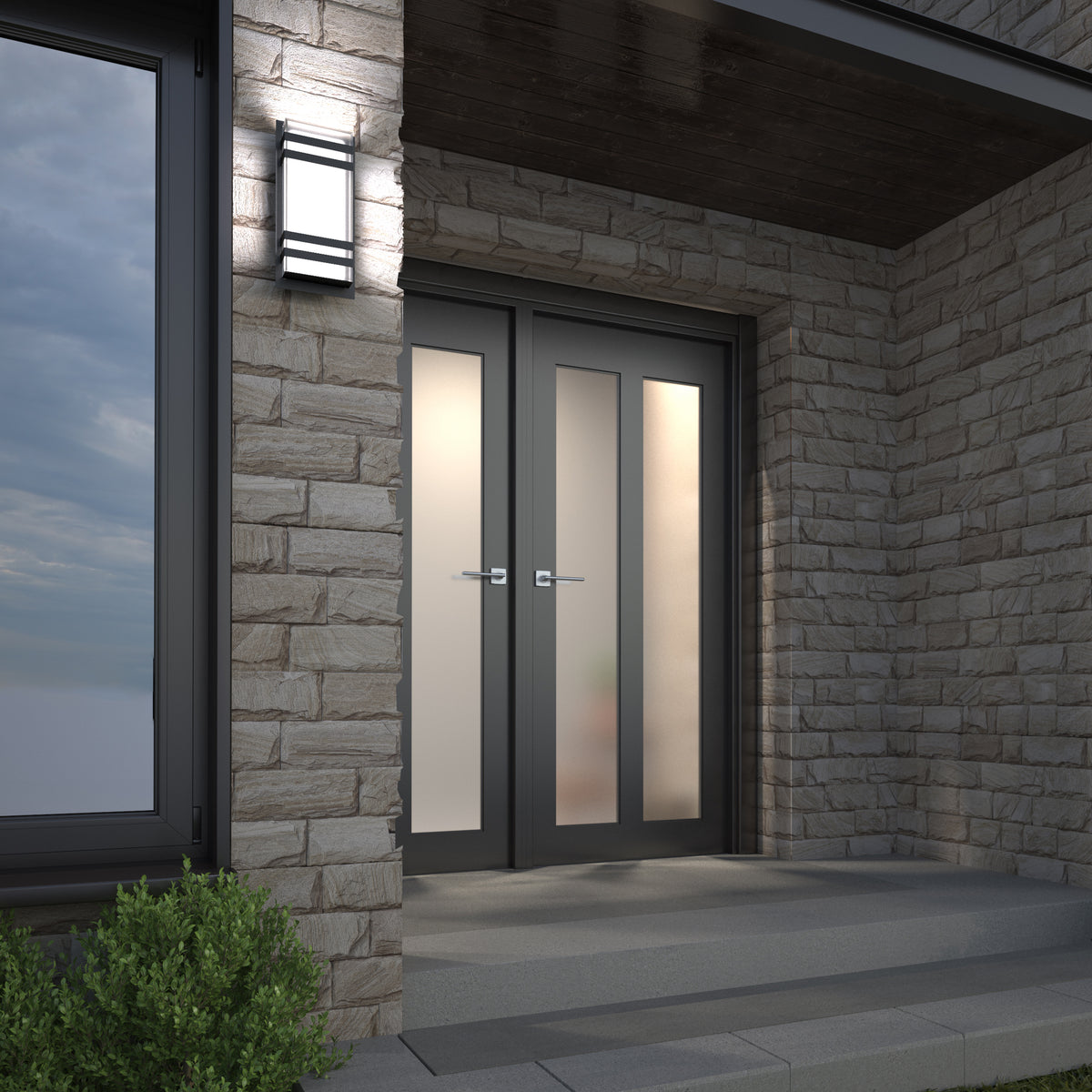 Modern double glass doors with frosted panels set in a stone wall, illuminated by the Artika Glowbox 3 indoor-outdoor LED wall light above wide gray steps, with greenery visible in the corner.