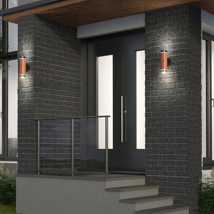 Modern house entrance with black brick walls, double glass front doors, metal railing, and two Artika C7 indoor-outdoor LED wall lights (3 CCT) illuminating the entryway. Steps lead up to the small porch area.