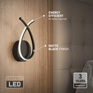 The Artika Gamma modern LED wall sconce 5 CCT features energy efficiency, integrated LEDs (no bulbs needed), a matte black finish, and comes with a 3-year warranty. Perfect as a sleek wall lamp beside your bed.