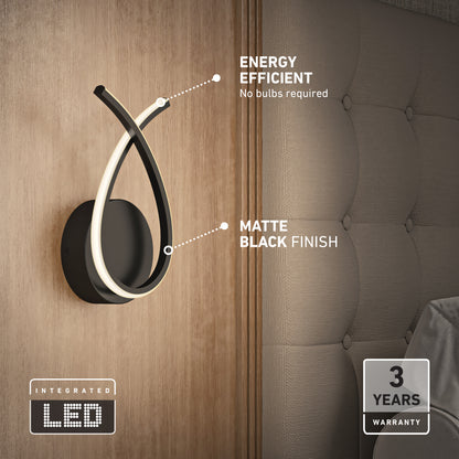 The Artika Gamma modern LED wall sconce 5 CCT features energy efficiency, integrated LEDs (no bulbs needed), a matte black finish, and comes with a 3-year warranty. Perfect as a sleek wall lamp beside your bed.