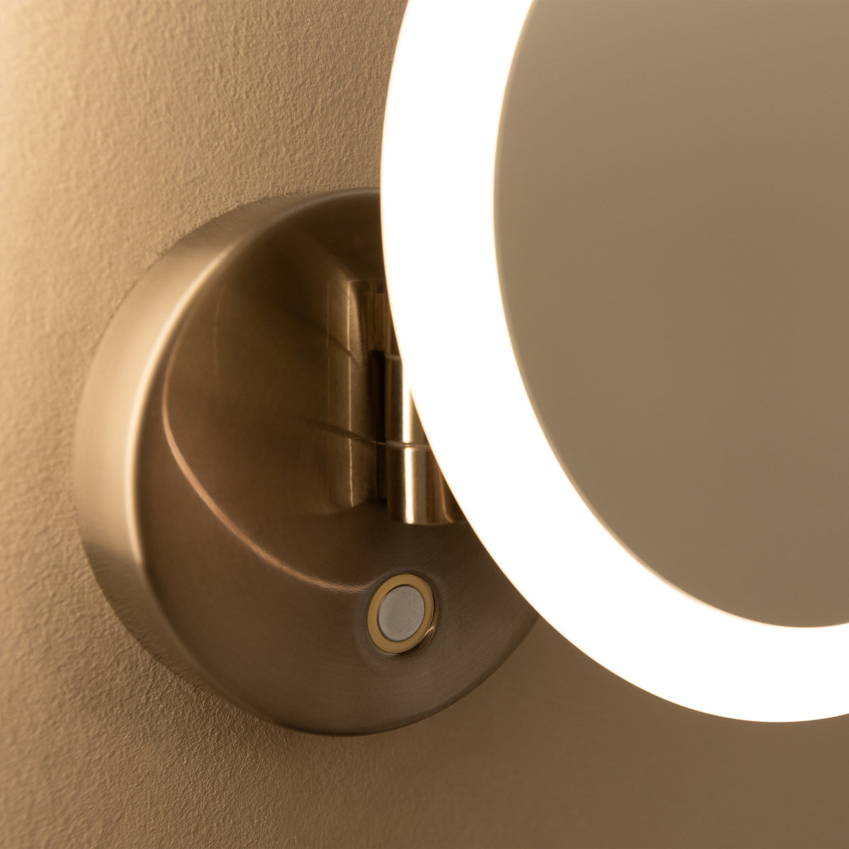 Close-up of the Artika Radia 9 in. Cordless LED Cosmetic Mirror with bright ring light and metallic base on a beige wall.